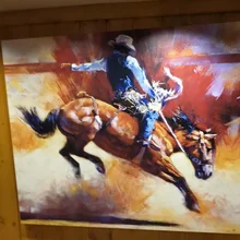 painting of a rodeo rider on a bucking horse with dust and dynamic brush strokes